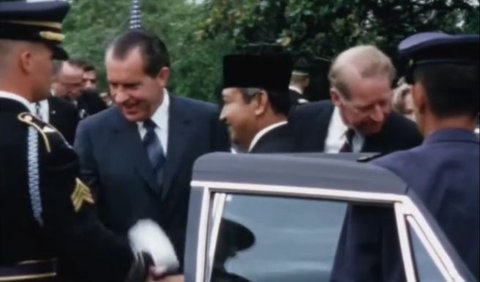 Menggunakan setelan jas dan peci berwarna hitam, Soeharto disambut langsung oleh presiden Nixon saat turun dari mobil.