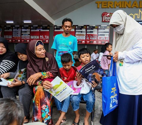 Badan Bahasa Kementerian Pendidikan, Kebudayaan, Riset, dan Teknologi (Kemendikbudristek)  membagikan buku bacaan cerita gratis untuk anak-anak pemudik di Terminal Kalideres, Jakarta Barat, Selasa (2/4/2024). Foto: Liputan6.com / Angga Yuniar