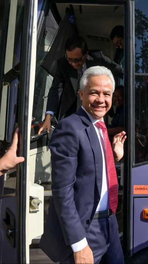 Momen ketika Ganjar Pranowo tiba dengan bus di Gedung Mahkamah Konstitusi sebelum sidang putusan dimulai. Wajah mantan Gubernur Jawa Tengah itu terlihat tersenyum cerah. Foto: AFP