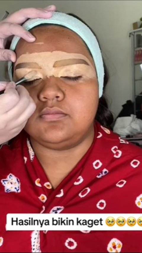 After moisturizing the face of the woman with dark skin, the MUA immediately tidies up the eyebrows.