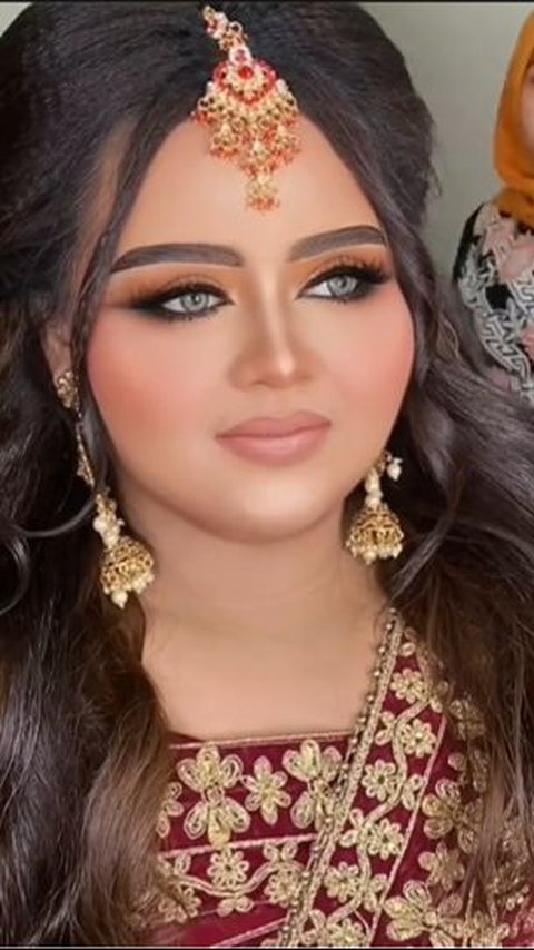 This is the result of the Bollywood-style makeup. Her face looks very different from before being made up.
