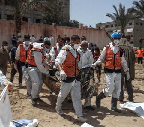 Sejumlah warga dan petugas kesehatan mengevakuasi jenazah di kuburan massal yang ditemukan di Rumah Sakit (RS) Al-Nasser, Jalur Gaza, Palestina, pada 23 April 2024. Kuburan massal dengan ratusan mayat ditemukan di dua rumah sakit Jalur Gaza yang sebelumnya dikuasai tentara Israel, yakni RS Al-Shifa dan RS Al-Nasser. Foto: AFP