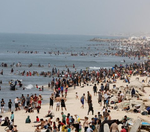 Tak sedikit warga Palestina menikmati waktu santainya di pantai Gaza dengan berjemur dan berenang di musim panas saat ketegangan antara Israel dan Hamas masih berlangsung di Rafah, di selatan Jalur Gaza, 24 April 2024. Foto: REUTERS / Mohammed Salem