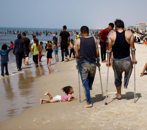FOTO: Jernihkan Pikiran dari Trauma Perang, Warga Palestina Bondong-Bondong Padati Pantai Gaza saat Musim Panas