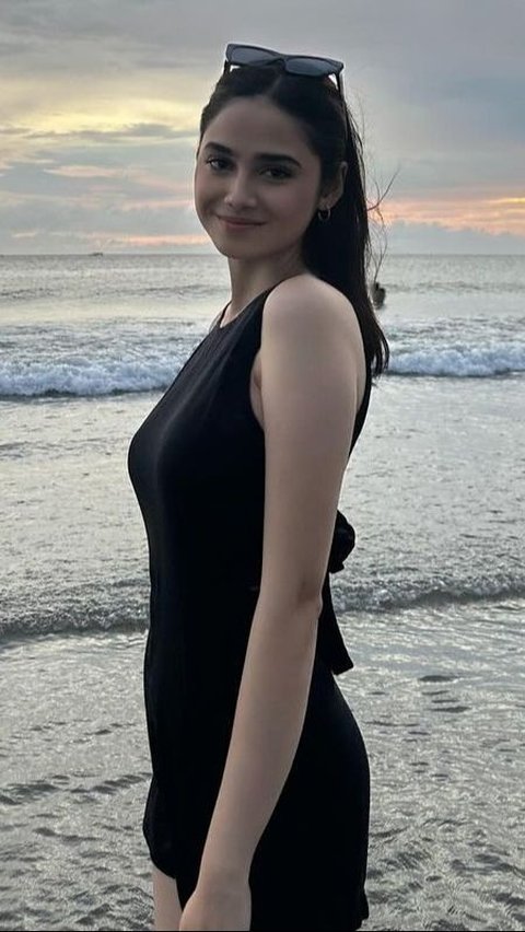 When at the beach, Syifa Hadju wears a black sleeveless mini dress with a ribbon accent at the back.