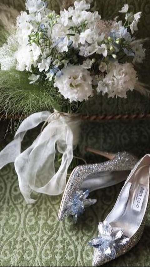 Sepatu ini diberi detail bunga dan aksen berkilauan dari kristal Swarovski.