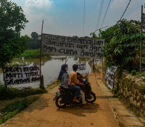 Warga memutar sepeda motornya ketika banjir akibat longsor TPA Cipayung merendam jalanan di Depok, Jawa Barat, Selasa (30/4/2024). Sudah lebih dari satu tahun, sampah di TPA Cipayung yang overload longsor dan menimbun sebagian badan Kali Pesanggrahan. Merdeka.com/Arie Basuki