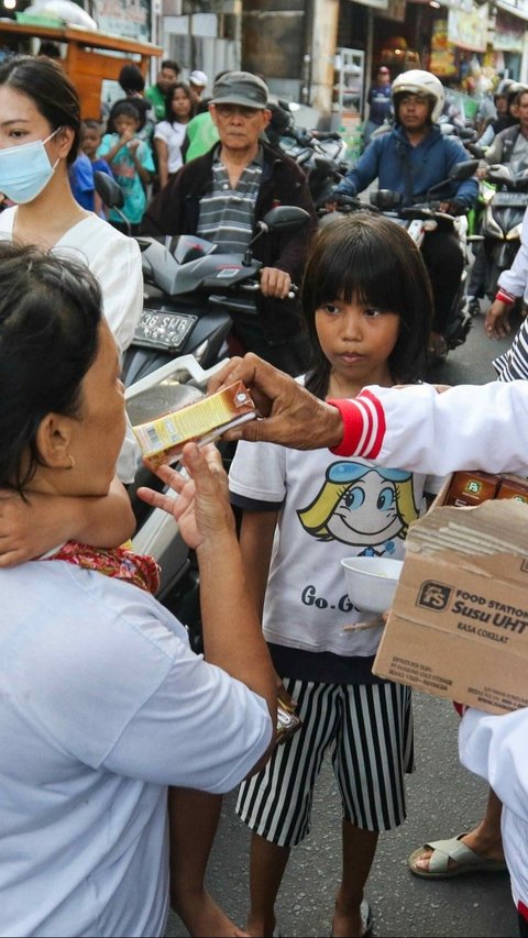 Mereka dengan sukarela menyediakan dan membagikan susu kepada warga yang melintas. Foto: Liputan6.com / Herman Zakharia