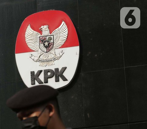 Petugas dari kepolisian melintas di dekat logo KPK di lobby Gedung Merah Putih KPK, Jakarta, Selasa (1/6/2021). Pengamanan gedung KPK dan sekitarnya diperketat terkait upacara pelantikan pegawai KPK menjadi Aparatur Sipil Negara. (Liputan6.com/Helmi Fithriansyah)