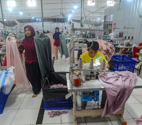 Pekerja menyelesaikan pekerjaan terakhir pembuatan mukena  jelang libur hari Lebaran 2024 pada pabrik busana muslim Siti Khadijah di kawasan Limo, Depok, Jawa Barat, Kamis (04/04/2024). Foto: merdeka.com / Arie Basuki<br>
