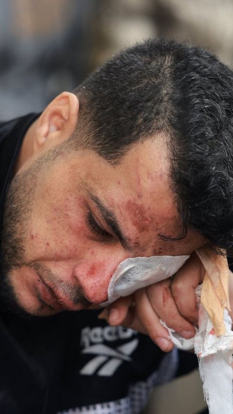 Ashraf pun tak bisa menahan air matanya yang terus mengalir deras. Foto: Mohammed ABED / AFP<br>