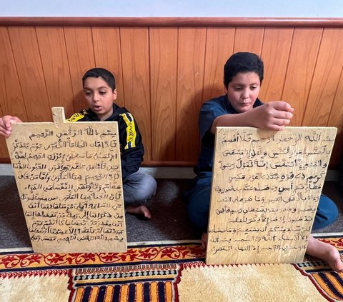 FOTO: Melihat Cara Unik Anak-Anak Libya Belajar Baca Tulis Alquran dengan Cepat Menggunakan Papan Kayu
