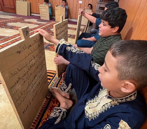 Anak-anak Libya masih menggunakan metode pembelajaran Alquran zaman nabi dengan memakai papan kayu hingga sekarang. Foto: REUTERS / Ayman al-Sahili