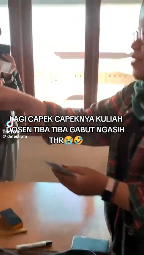 Inilah momen saat dosen wanita yang masih cukup muda membagikan THR pada mahasiswanya.