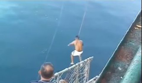 Pria bertelanjang dada dengan sigap lompat ke air laut dan berenang hingga menyelamatkan penumpang. 