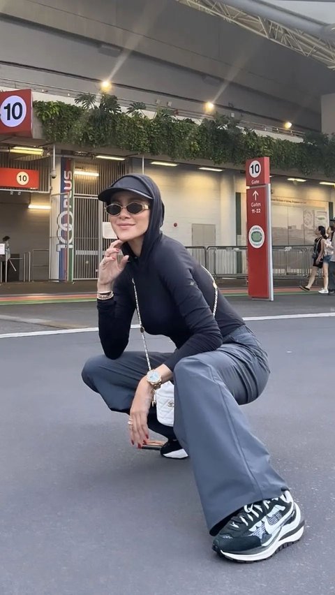 Olla Ramlan looks cool with a black hoodie and her cap combined with gray flare pants and her Nike sneakers.