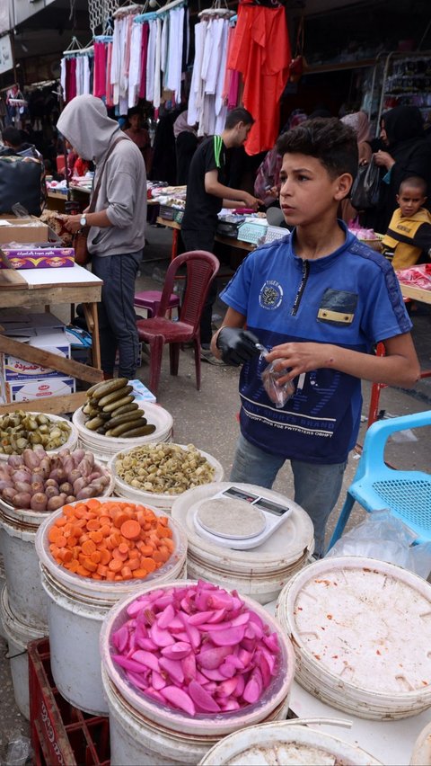 Di pasar itu mereka berjualan makanan dan minuman. Foto: MOHAMMED ABED / AFP<br>