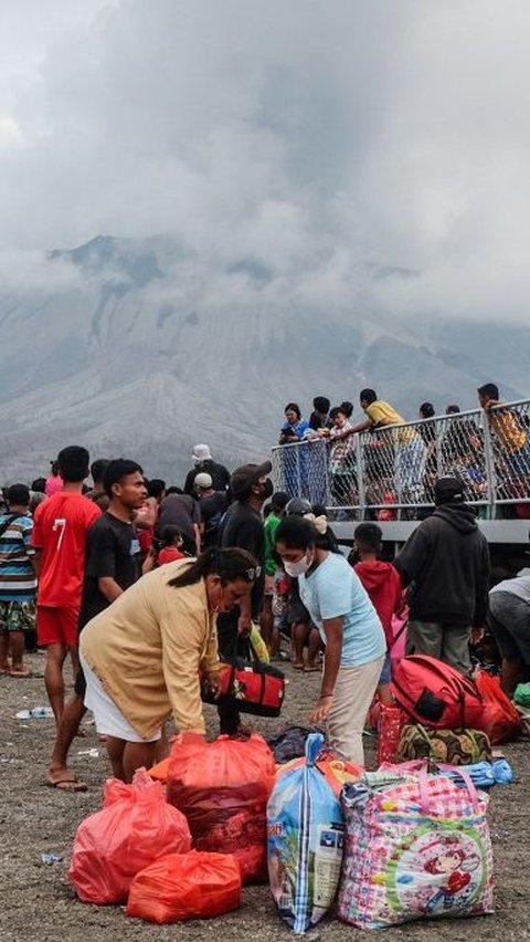 Ribuan orang yang tinggal di pulau-pulau terdekat Gunung Ruang pun secara bertahap menyelamatkan diri. Mereka menaiki sejumlah kapal evakuasi yang dikerahkan TNI AL, Polri, hingga Basarnas. Foto: Ronny Adolof Buol/AFP