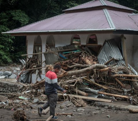 Dari pantauan di lokasi, banjir lahar dingin membawa material batu-batu hingga batang pohon.<br><br>Bencana ini juga mengakibatkan setengah badan jalan raya longsor. Foto: REZAN SOLEH / AFP