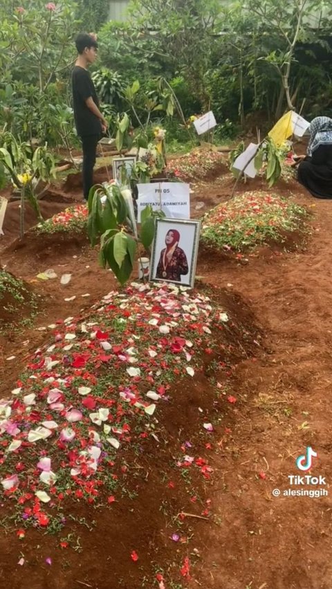 Dalam potret ini, tampak dua orang yang tengah mengunjungi makam teman-temannya.