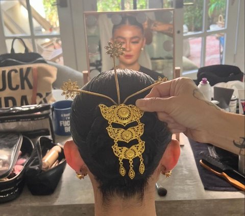 Portrait of Agnez Mo Wearing Hairpin and Batik Dress on the Red Carpet Gold Gala