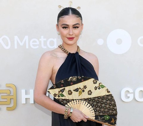 Portrait of Agnez Mo Wearing Hairpin and Batik Dress on the Red Carpet Gold Gala