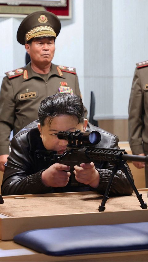 Dengan memicingkan mata kirinya, Kim mencermati target sembari menarik pelatuk. Gayanya tampak mirip seorang sniper yang menembak musuhnya. KCNA VIA KNS/AFP
