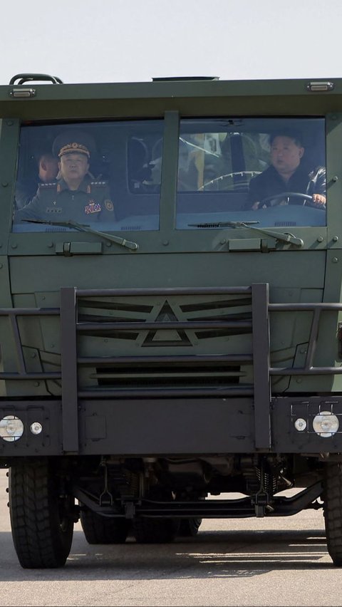 Kim Jong-un membawa salah satu unit truk untuk berkeliling lokasi pabrik. KCNA VIA KNS/AFP