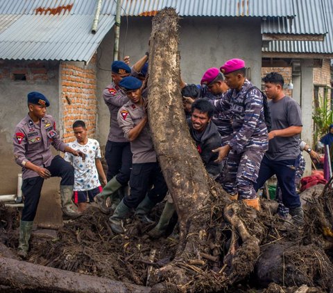 Tim penyelamat dan warga memindahkan kayu-kayu yang terbawa banjir bandang saat mencari korban hilang di Desa Batu Taba, Kabupaten Agam, Sumatera Barat (Sumbar), Selasa (14/5/2024). Tim SAR gabungan terus berjibaku melakukan pencarian terhadap korban banjir bandang lahar dingin dan longsor di Sumbar. Foto: Rezan Soleh/AFP