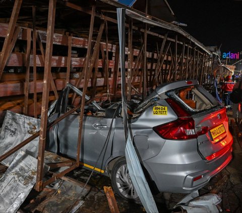 Kondisi sebuah mobil yang rusak berat setelah tertimpa papan reklame raksasa di Mumbai, India, pada 13 Mei 2024. Sebanyak 14 orang dilaporkan tewas ketika terjangan badai menyebabkan sebuan papan reklame raksasa runtuh. Foto: Punit Paranjpe/AFP