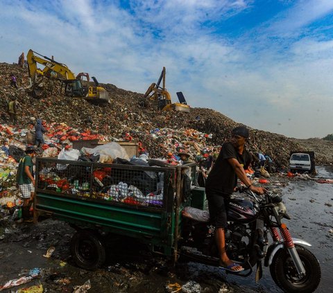 Petugas membuang sampah pada lokasi yang sebelumnya menjadi titik longsor di Tempat Pembuangan Akhir (TPA) Cipayung, Depok, Jawa Barat, Rabu (15/5/2024). Hari ini, aktivitas pembuangan sampah di TPA Cipayung kembali normal setelah sebelumnya ditutup dua hari karena longsor. Merdeka.com/Arie Basuki<br>