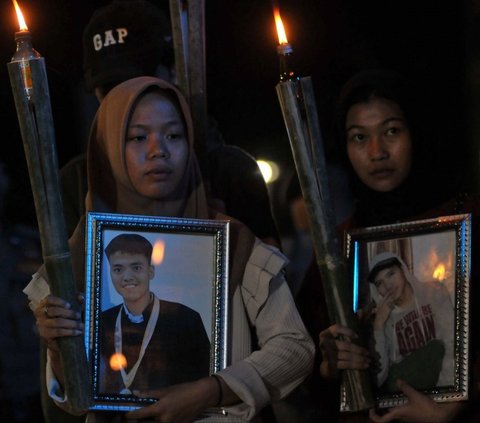 Dua di antara pelajar se-Jabodetabek membawa foto korban dan obor saat menggelar aksinya di depan Kantor Kementerian Pendidikan dan Kebudayaan, Jakarta, Rabu (15/5/2024). Foto: merdeka.com / Imam Buhori