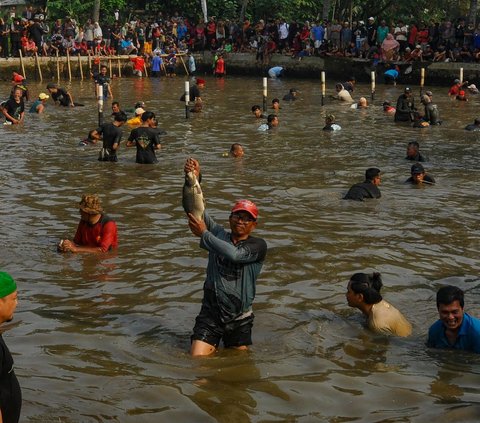 FOTO: Antusiasme Warga Berebut Ikan Saat Tradisi Ngubek Empang Jelang Lebaran Depok