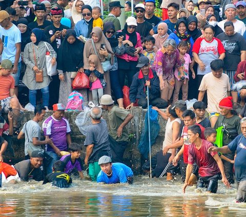 FOTO: Antusiasme Warga Berebut Ikan Saat Tradisi Ngubek Empang Jelang Lebaran Depok