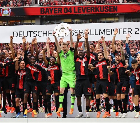 Kiper Bayer Leverkusen, Lukas Hradecky mengangkat trofi juara Bundesliga 2023/2024 di Stadion BayArena, Leverkusen, Jerman, Sabtu (18/5/2024) malam WIB. Kesuksesan Bayer Leverkusen menjuarai Bundesliga ini semakin sepektakuler setelah menutup musim dengan kemenangan 2-1 atas Augsburg. Foto: REUTERS/Wolfgang Rattay