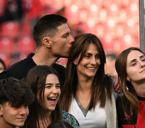 Pelatih Bayer Leverkusen, Xabi Alonso mencium istrinya, Nagore Aranburu saat merayakan gelar juara Bundesliga 2023/2024 di Stadion BayArena, Leverkusen, Jerman, Sabtu (18/5/2024) malam WIB. Xabi Alonso meraih kesuksesan spektakuler dengan mengantarkan Bayer Leverkusen meraih trofi juara Bundesliga pertamanya. Foto: Ina Fessbender/AFP