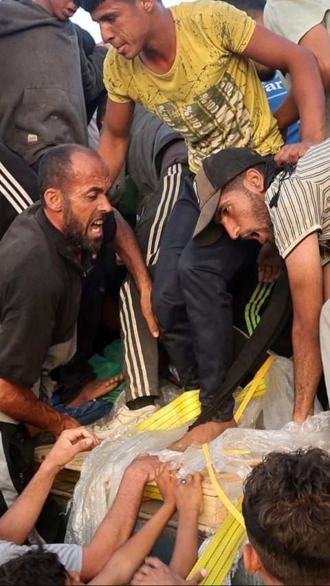 Dalam foto-foto ini memperlihatkan wajah-wajah para pengungsi Palestina yang kelelahan saat membongkar paksa truk-truk yang membawa makanan dan barang-barang lainnya. Foto: REUTERS / Ramadan Abed<br>