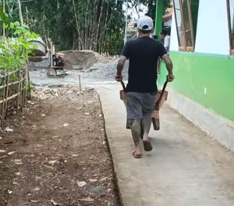 Badan Penuh Tato, Kades Hoho Tak Gengsi Mendorong Gerobak Sorong Bawa Adukan Semen Untuk Perbaikan Jalan