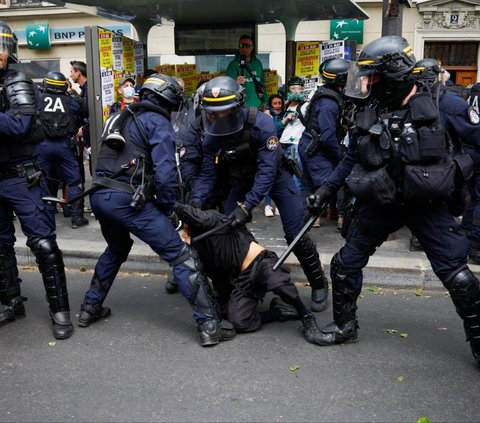Aparat kepolisian menangkap seorang pengunjuk rasa dalam aksi peringatan May Day atau Hari Buruh Sedunia di Paris, Prancis, pada Rabu (1/5/2024). Aksi May Day di berbagai negara diwarnai dengan bentrokan antara kaum buruh dan aparat kepolisian. REUTERS/Sarah Meyssonnier
