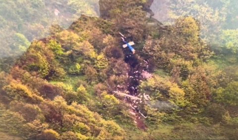 Dalam foto yang dirilis Press TV, helikopter berwarna biru itu terlihat jatuh menghantam gunung dan tergelincir dari gunung yang curam dan dipenuhi vegetasi.