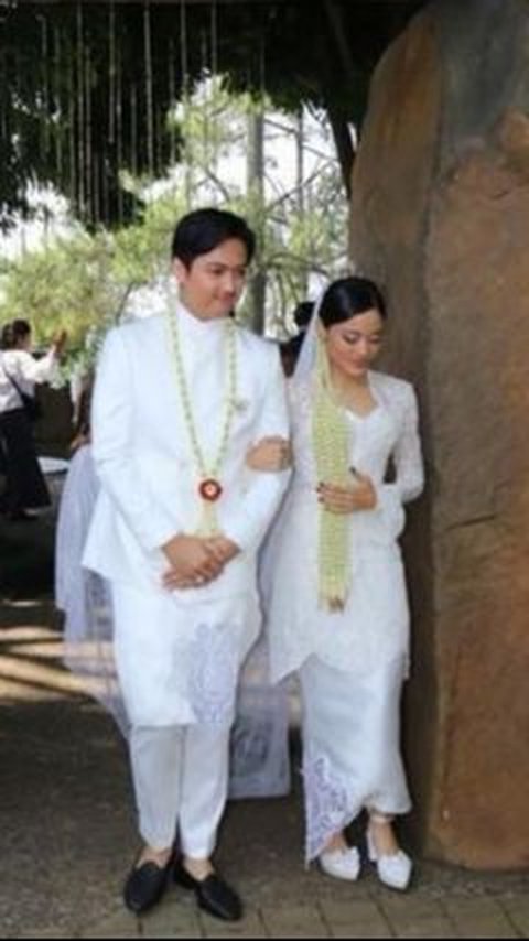 Pasangan pengantin ini tampil serasi memakai baju pengantin bernuansa putih.