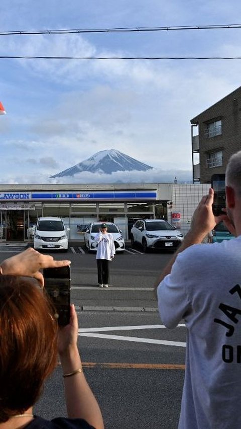 Hampir saban hari, turis datang ke lokasi tersebut untuk berburu foto dengan pemandangan gunung yang puncaknya berselimut salju tersebut. Foto: Kazuhiro Nogi/AFP<br>