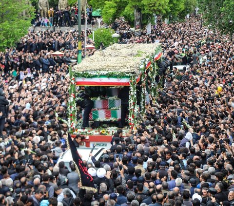 Lautan manusia memadati iring-riringan truk yang membawa jenazah Presiden Ebrahim Raisi dan tujuh pendampingnya di Tabriz, Provinsi Azerbaijan Timur, Iran, Selasa (21/5/2024). Meninggalnya Presiden Ebrahim Raisi menimbulkan duka mendalam bagi publik Iran. Foto: Ata Dadashi/MOJ News Agency/AFP