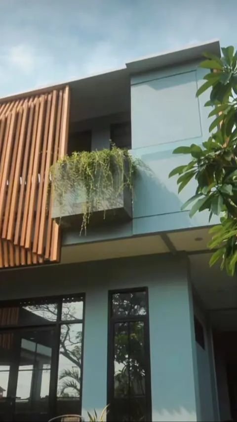 Rumah dua tingkat ini didominasi oleh warna abu-abu yang dipadukan dengan sentuhan kayu.