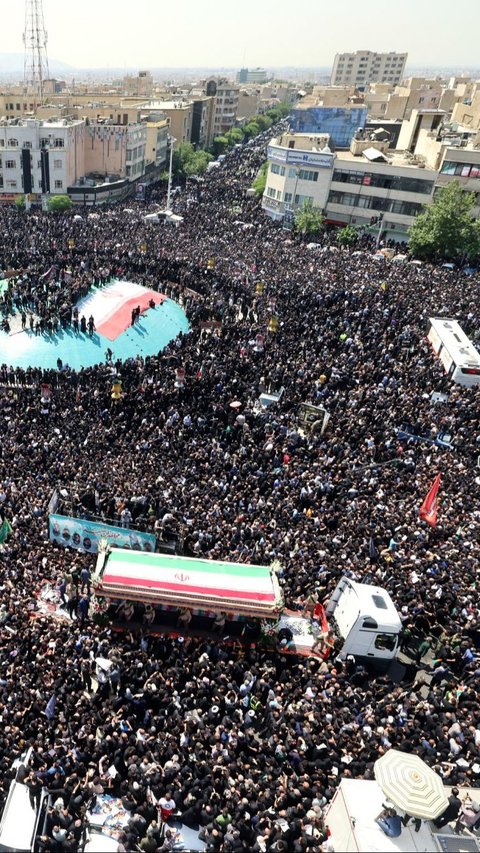 Iring-iringan jenazah Ebrahim Raisi di Teheran disambut jutaan warga berpakaian serba hitam. Suasana penuh duka tampak menyelimuti momen tersebut. Foto: Atta Kenare/AFP