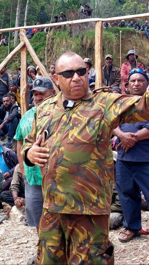 Perwira Angkatan Pertahanan Papua Nugini Michael Band berbicara dengan penduduk setempat di lokasi tanah longsor yang menewaskan lebih dari 670 orang di desa Mulitaka, Provinsi Enga, Papua Nugini, (26/5/2024). Foto: AFP / STR