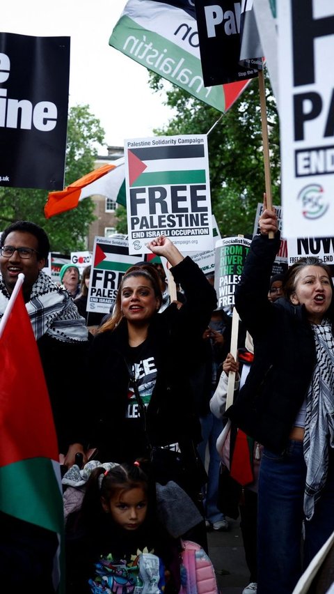 Pengunjuk rasa membawa berbagai poster seruan kemerdekaan Palestina saat menggelar aksi solidaritas untuk Palestina di London, Inggris, pada 28 Mei 2024. Foto: Benjamin Cremel/AFP