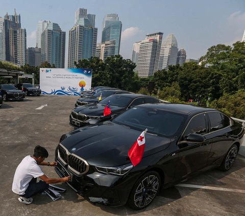 Petugas membersihkan mobil BMW i7 dan i5 di kompleks Gelora Bung Karno (GBK), Senayan, Jakarta, Jumat (3/5/2024). BMW Group Indonesia menyerahkan 51 unit mobil listrik mewah kepada Kementerian Sekretariat Negara. Foto: Liputan6.com/Angga Yuniar