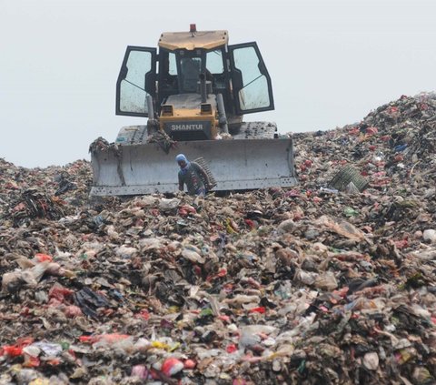 Alat berat eskavator  meratakan gunungan sampah di tempat Pembuangan Sampah Akhir (TPA) Burangkeng, Bekasi, Jawa Barat Senin (6/5/2024). TPA Burangkeng rencananya akan memperluas lahan pembuangan sampah. Foto: merdeka.com / Imam Buhori<br>