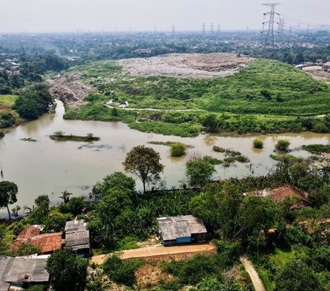 Sebuah pemandangan memprihatinkan yang potret dari udara memperlihatkan tumpukan sampah yang menjulang tinggi hingga menghalangi aliran sungai dan menyebabkan pemukiman warga di sekitar Depok terendam banjir pada 7 Mei 2024. Foto: AFP / Bay Ismoyo